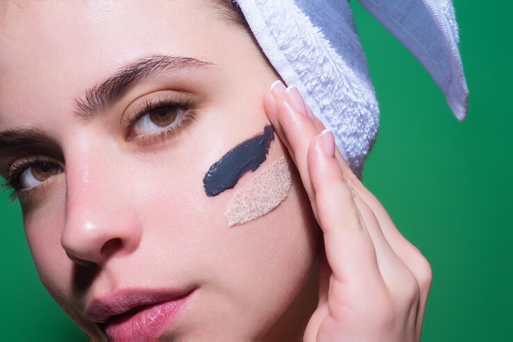 Foto feche o creme facial na bochecha, cuidado com a pele, o retrato de beleza de uma linda mulher aplicando creme para o rosto é