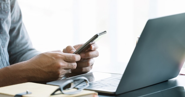 Feche o empresário usando telefone inteligente no escritório