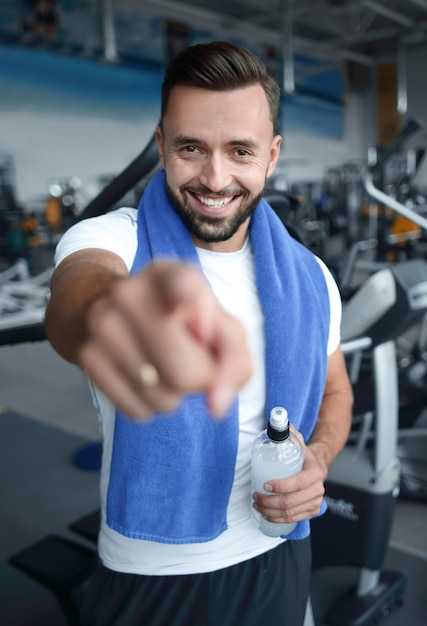 Feche o homem de esportes confiante apontando para você