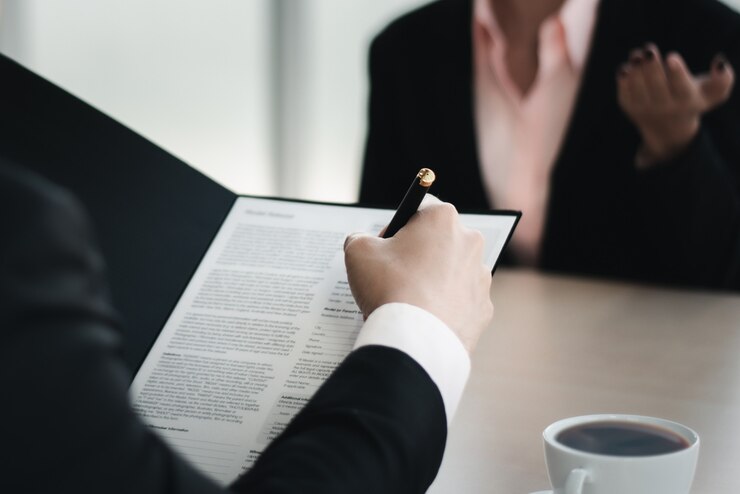 Feche o homem de negócios, escrevendo ou assinando contrato em papel no escritório.