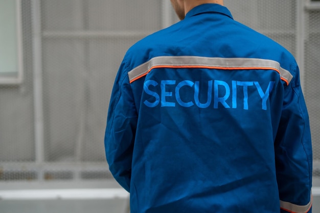 Feche o homem de uniforme com as palavras guarda de segurança nele