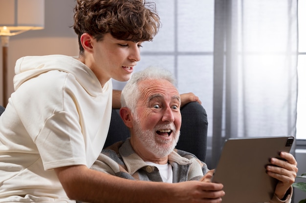 Foto feche o homem e o adolescente com tablet