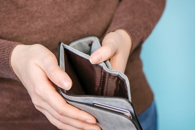 Feche o homem pessoa segurando uma carteira vazia nas mãos de um. homem sem dinheiro. Sem dinheiro para pagar compras, compra, venda ou pagamento.