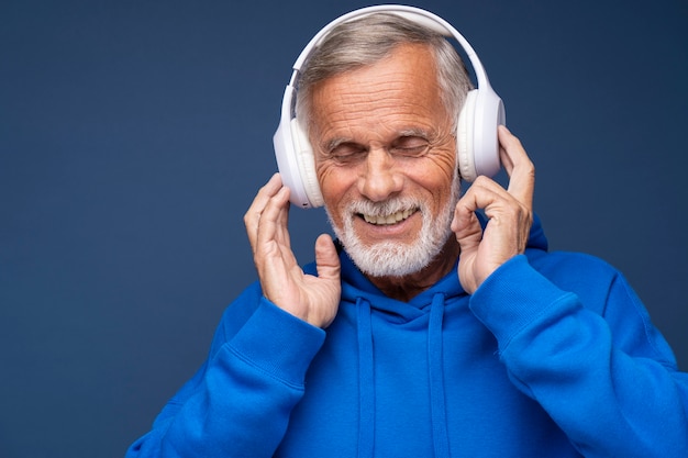 Feche o homem sênior usando fones de ouvido