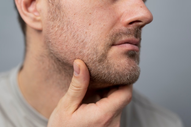 Foto feche o homem tocando sua barba