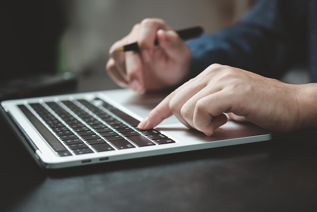 Feche o homem trabalhando e digitando no teclado do computador portátil trabalhe no conceito de aprendizado on-line de teletrabalho de escritório em casa