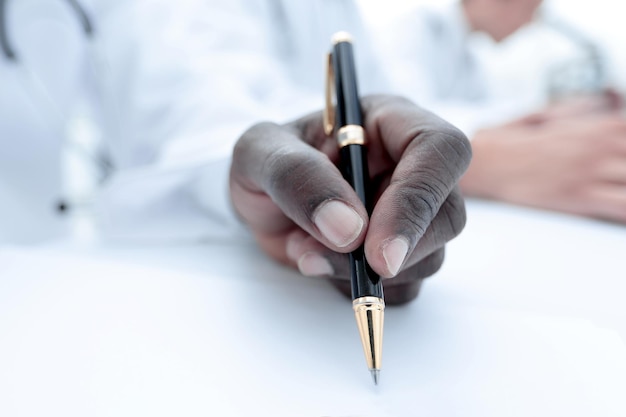 Feche o médico registrando os dados em um diário de laboratório