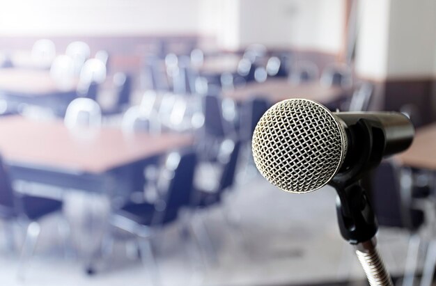 Feche o microfone com tripé no palco na sala de seminário