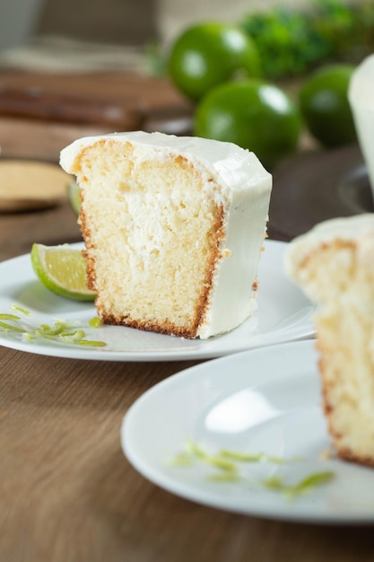 Feche o pedaço de bolo de frutas de limão úmido no prato com fatias de limão na mesa de madeira Delicioso café da manhã tradicional hora do chá Receita de bolo de limão