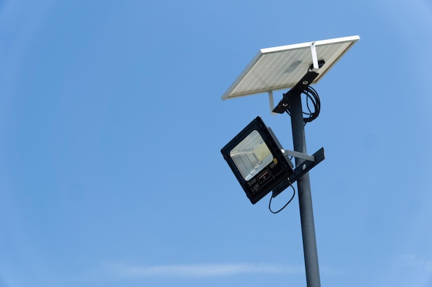 Feche o poste de iluminação de rua ou jardim com energia do painel de células solares contra o fundo do céu azul