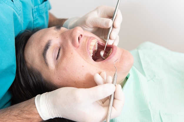 Feche o quadro de um dentista fazendo uma verificação básica para um paciente