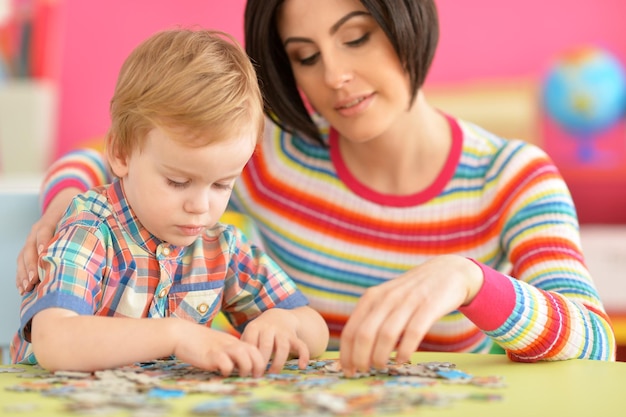 Feche o retrato da jovem mãe brincando com o filho