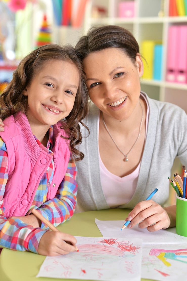Foto feche o retrato da mãe com a filha desenhando com lápis coloridos