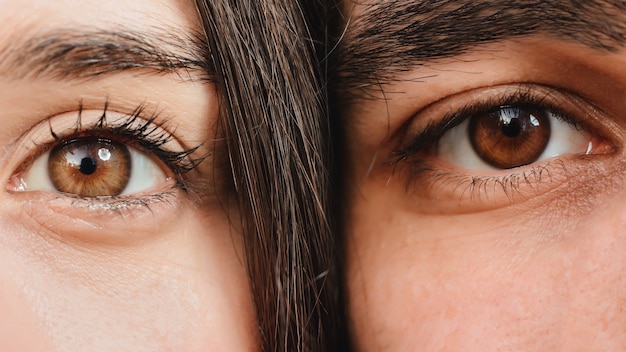 Feche o retrato da metade dos rostos de homem e mulher olhando para a câmera.