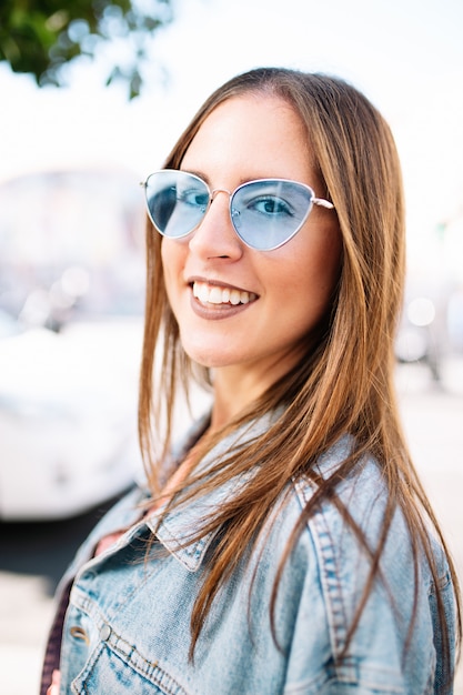 Feche o retrato de elegante sorridente feliz jovem na rua com dentes brancos perfeitos