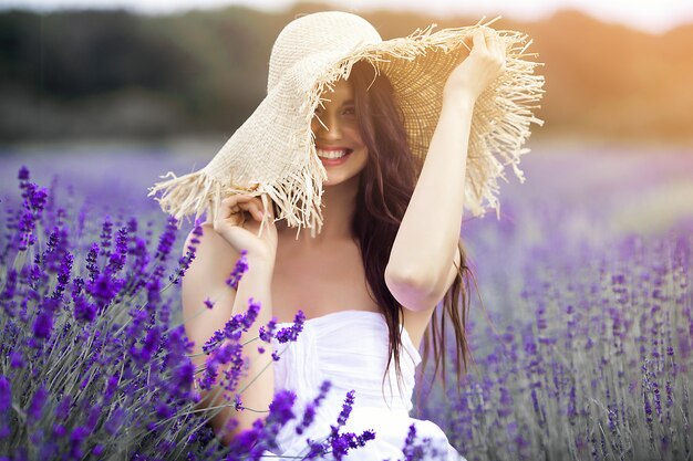 Feche o retrato de mulher jovem e bonita no campo de lavanda.