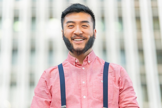 Feche o retrato de um homem asiático sorrindo lá fora