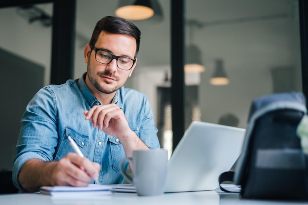 Feche o retrato de um homem bonito trabalhando em home office