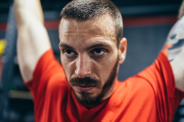 Feche o retrato de um homem levantando peso em uma academia