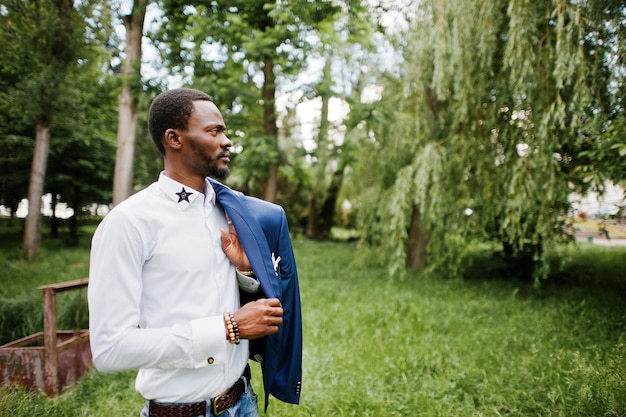 Feche o retrato de um homem negro elegante com jaqueta na mão