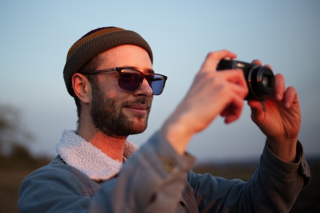 Feche o retrato de um jovem tirando foto com a câmera digital