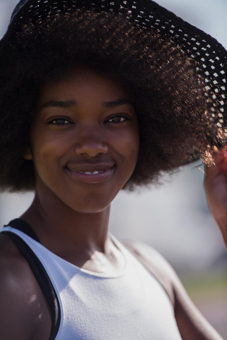Foto feche o retrato de uma bela jovem afro-americana sorrindo e olhando para cima em um lindo dia ensolarado