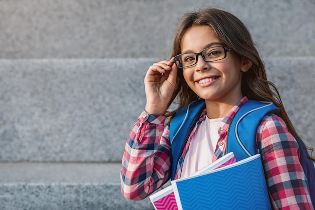 Feche o retrato de uma jovem caucasiana feliz com mochila segurando o notebook