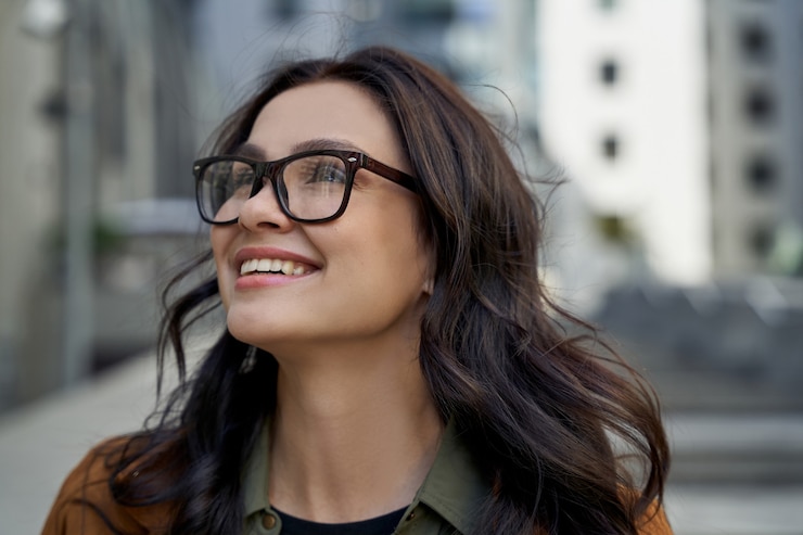 Foto feche o retrato de uma jovem encantadora feliz usando óculos, olhando para o lado e sorrindo