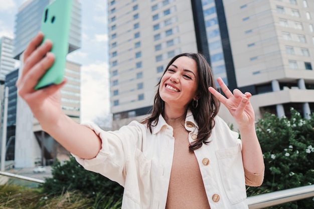 Feche o retrato de uma jovem feliz sorrindo tirando um retrato de selfie com um celular