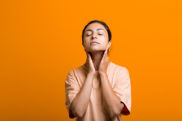 Feche o retrato de uma jovem indiana americana fazendo ioga de construção facial ginástica de rosto ioga auto-massagem