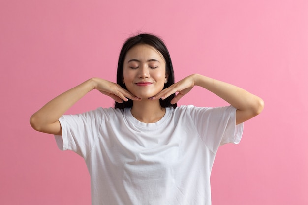 Feche o retrato de uma jovem mulher asiática fazendo facebuilding ioga rosto ginástica ioga massagem.