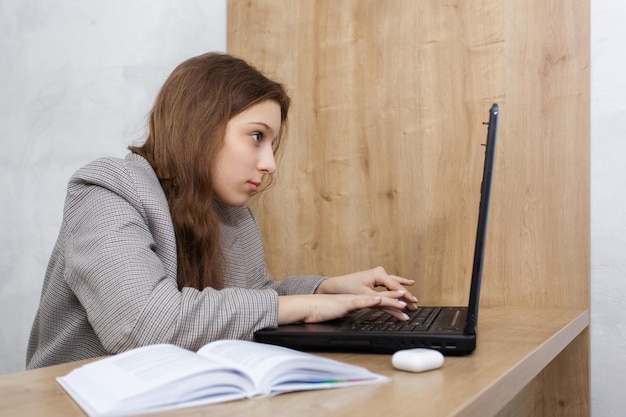 Feche o retrato de uma jovem olhando para o laptop pensando em algo importante