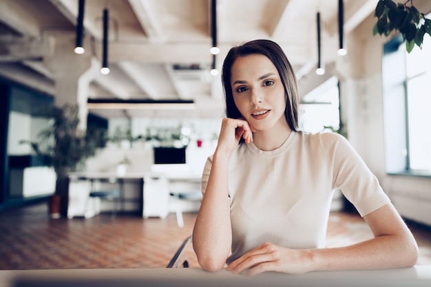 Feche o retrato de uma jovem que trabalha no escritório à mesa