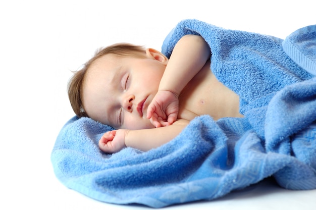 Feche o retrato de uma linda garotinha dormindo na toalha azul