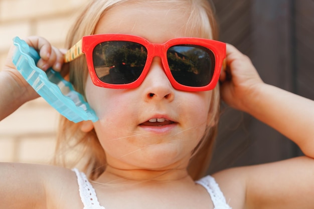 Feche o retrato de uma menina loira em um dia de verão