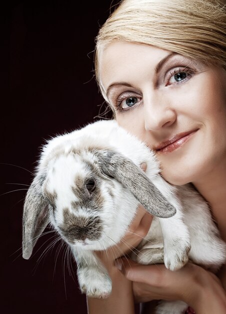 Foto feche o retrato de uma menina segurando um coelho