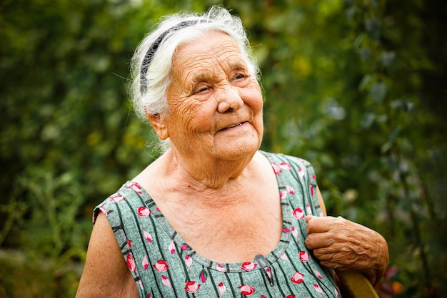 Feche o retrato de uma mulher idosa em um jardim muito velha senhora de oitenta anos ao ar livre no verão