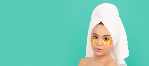 Feche o rosto de tratamento facial de menina adolescente em toalha de banho com remendo dourado Cosméticos e cuidados com a pele para design de cartaz de criança adolescente Banner de menina de beleza com espaço de cópia