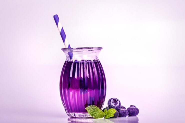 Foto feche o suco de mirtilo com folha de hortelã verde e frutas com bolinhas