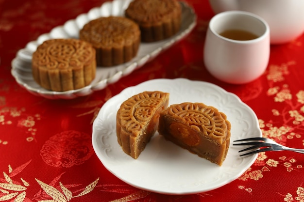 Feche os bolos da lua com fundo vermelho. Mooncake é uma padaria tradicional chinesa.