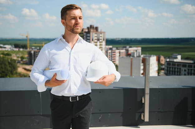 Feche os engenheiros que trabalham em um canteiro de obras segurando uma planta conceito de engenharia e arquitetura