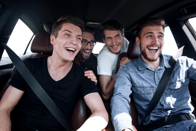 Feche três amigos viajando em um carro
