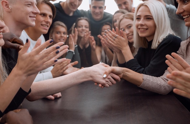 Feche um grupo de jovens aplaudindo em uma reunião de grupo