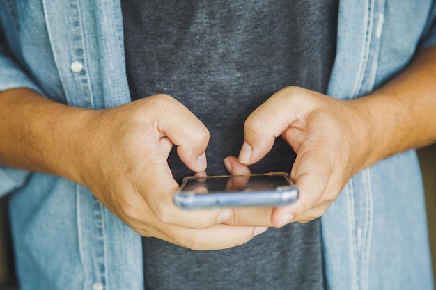 Foto feche um homem segurando uma mensagem de texto conversando com um amigo com telefone celular