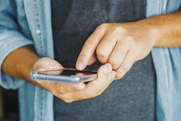 Feche um homem segurando uma mensagem de texto conversando com um amigo com telefone celular