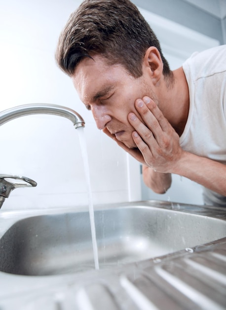 Feche um jovem lava no banheiro de manhã o conceito de higiene pessoal