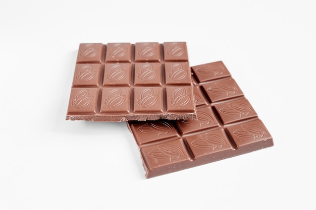 Feche uma barra de chocolate isolada no fundo branco