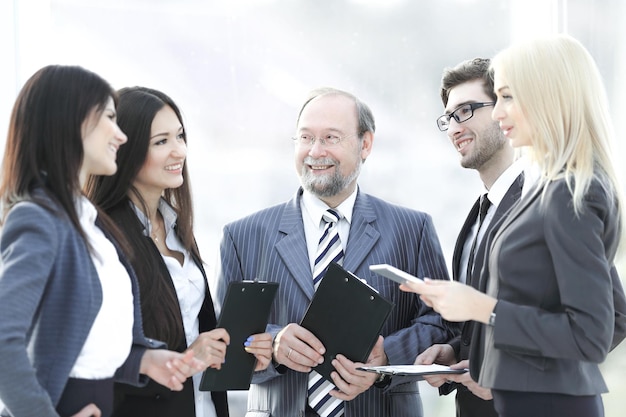 Feche uma equipe de negócios em pé conversando no escritório