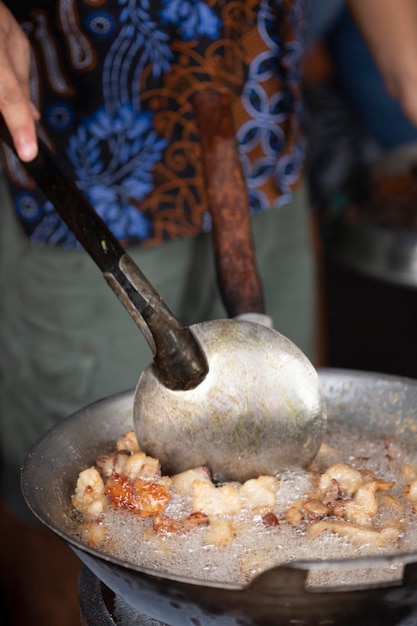 Feche uma mulher cozinhando de krenyos, uma comida tradicional popular de bantul yogyakarta.