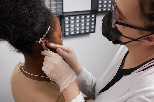 Fecho da orelha da mulher com piercing na orelha para tratamento da dor em algum lugar do corpo pelo médico chinês